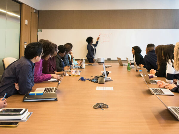 students around a conference table watching teacher