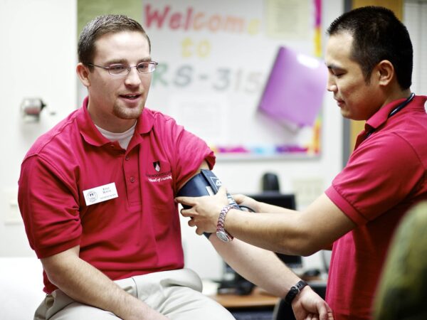 student taking another student's blood pressure