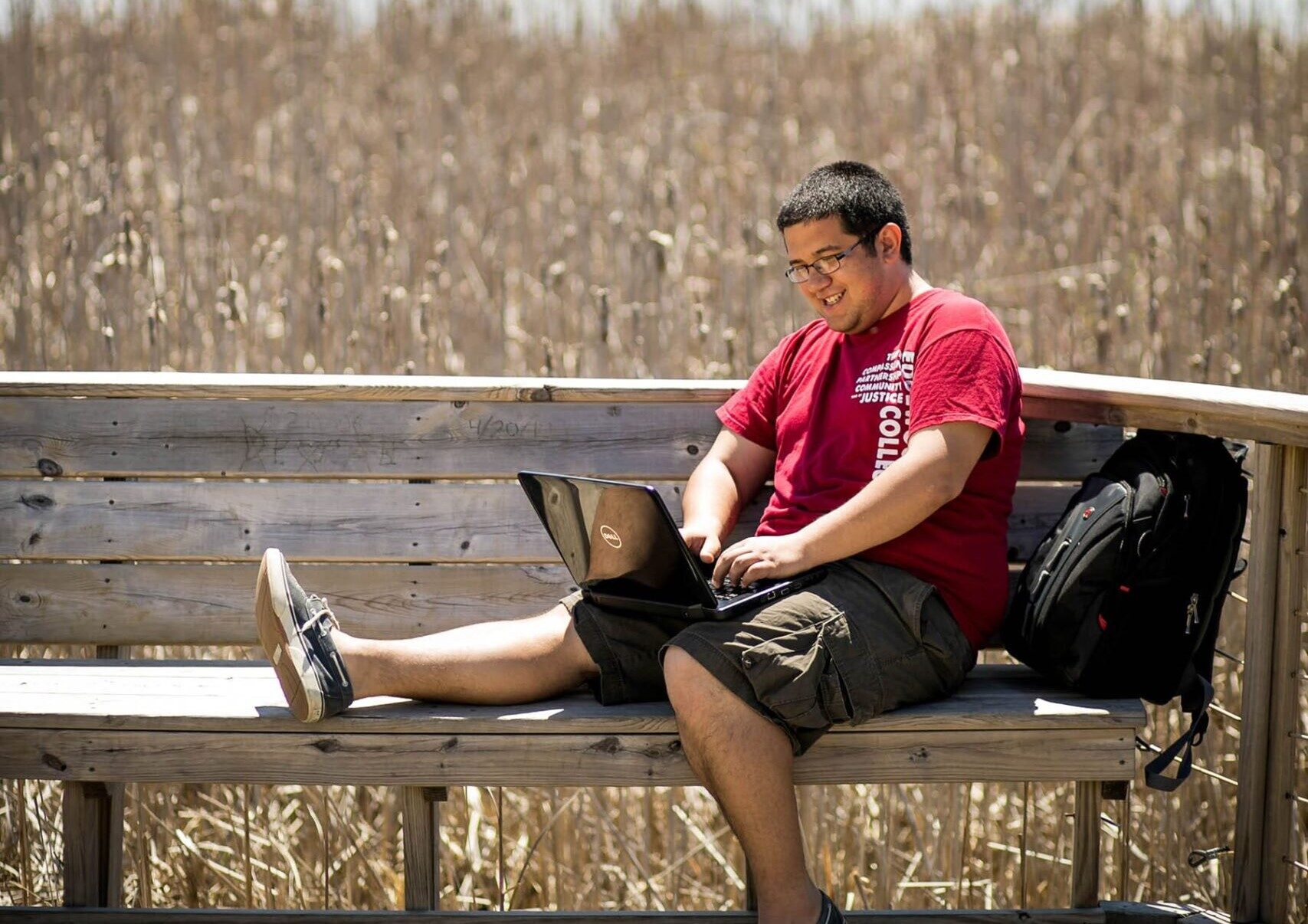 a person sitting on a bench with a laptop