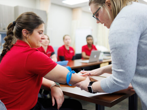 a person in a red shirt getting blood shot