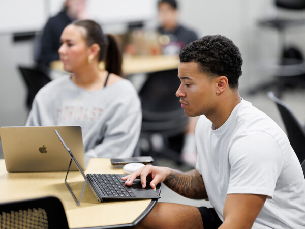 two students working on their laptops