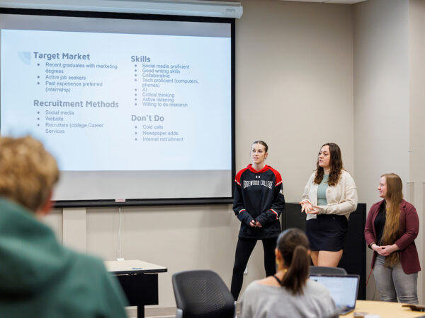 three students giving a presentation