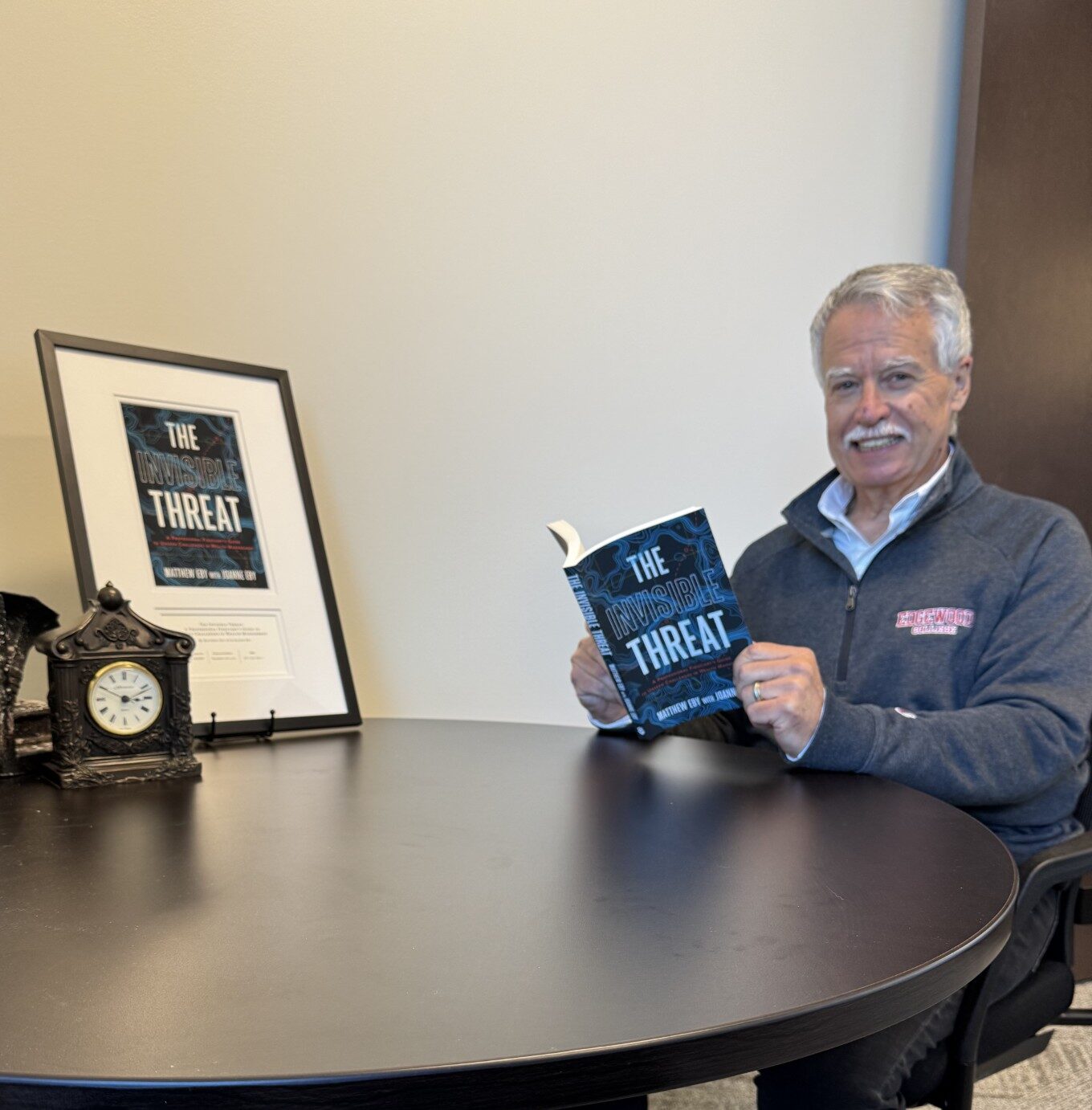 Matt Eby holding book titled The Invisible Threat