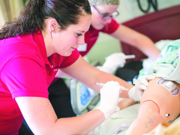 two health sciences students performing an examination