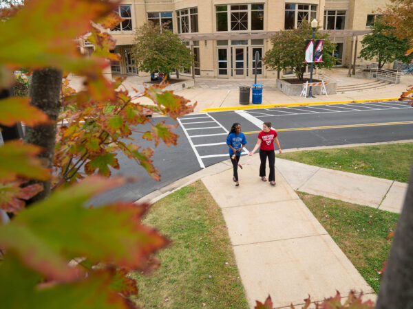 a couple of people walking on a sidewalk