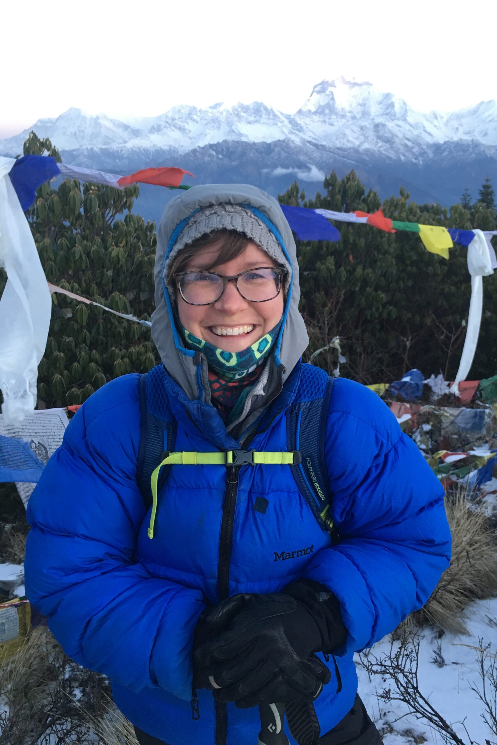 Woman standing on top of Nepal mountain smiling