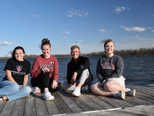 a group of women sitting on a dock